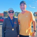 Photo of two people with achievement medal